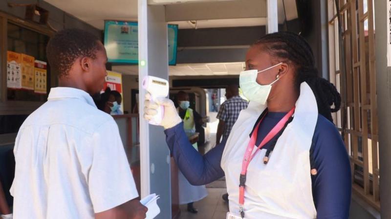 Medical worker checking temperature of traveller at Kenyan border