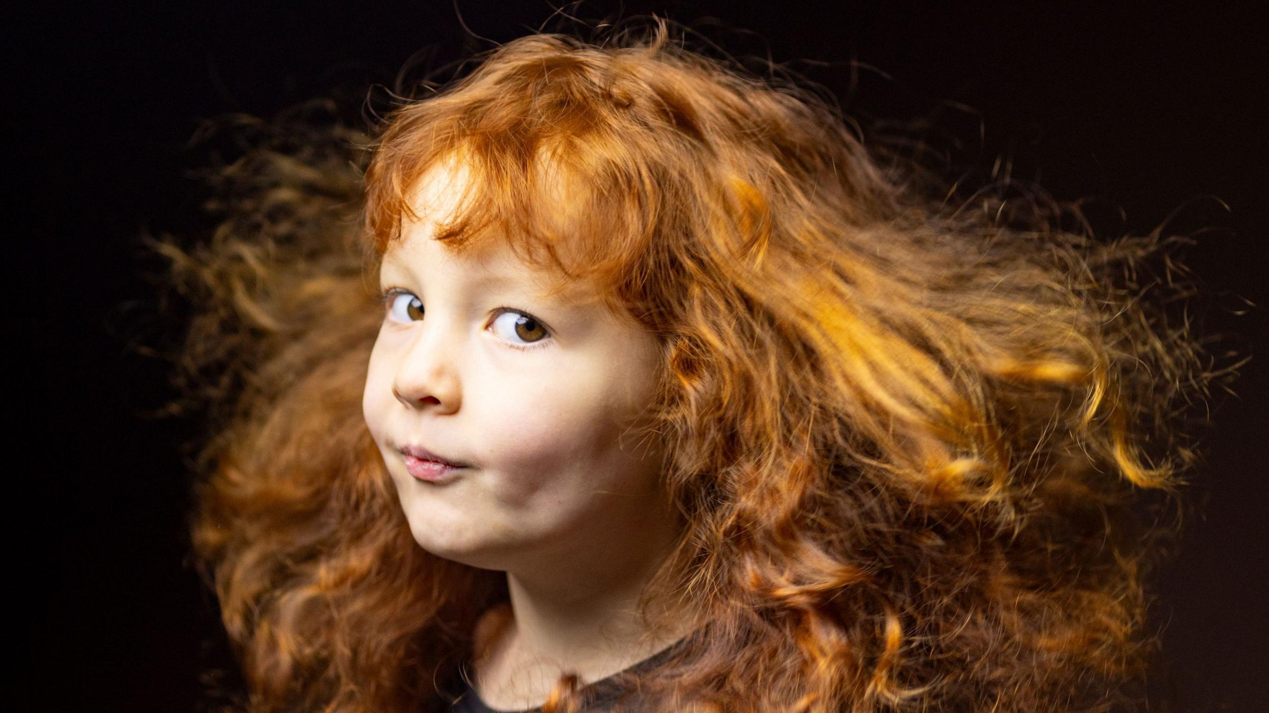 Portrait of a child with tightly curled red hair