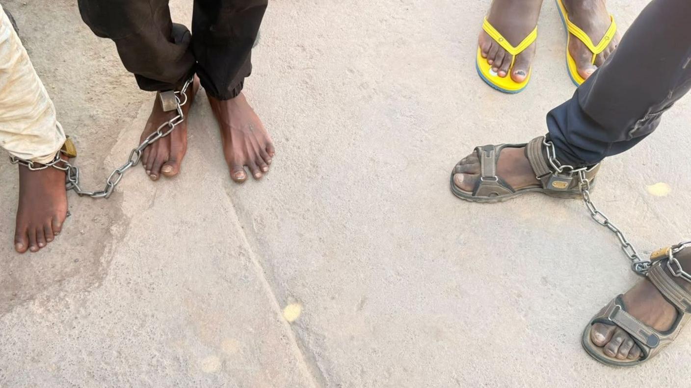 Men are seen with chains around their feet after they were found at a suspected rehab facility in South Africa