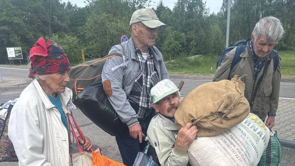 Four people carrying belongings leave Oleshky, Ukraine’s southern city occupied by Russia