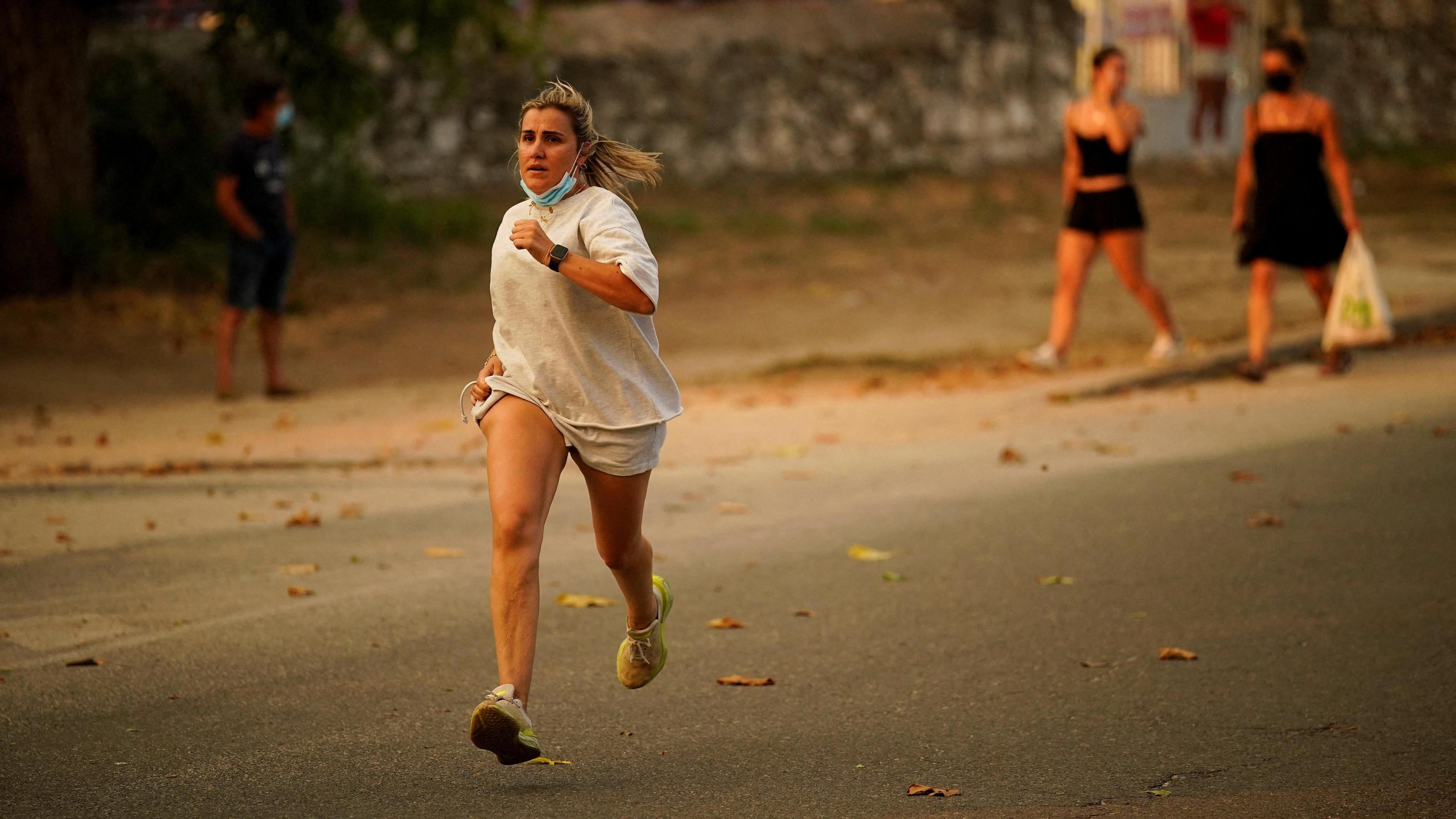 A person runs as the fire spreads in the mountains of Navaluenga, Avila, Spain