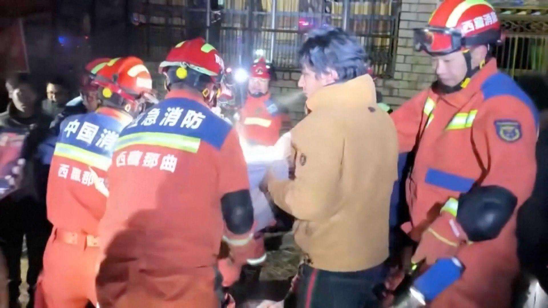 Firefighters are seen helping residents injured by the quake in Baqên, Tibet.